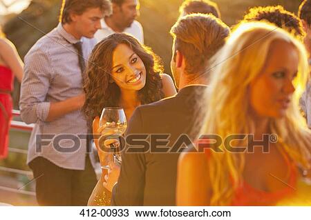 Smiling woman with wine glass talking to man on sunny balcony View Large Photo Image Stock Image - Smiling woman with wine glass talking to man on sunny balcony. Fotosearch