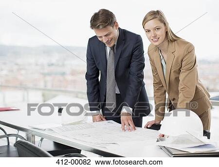Architects reviewing blueprints at desk View Large Photo Image Stock Image - Architects reviewing blueprints at desk. Fotosearch