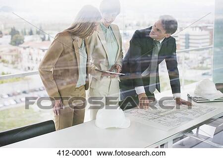 Architects with digital tablet reviewing blueprints in office View Large Photo Image Stock Image - Architects with digital tablet reviewing blueprints in office. Fotosearch