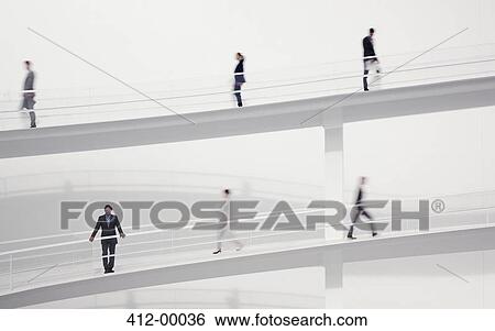 Stock Photograph - Blurred business people walking on elevated walkways. Fotosearch