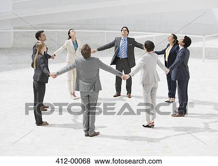 Business people holding hands in circle View Large Photo Image Stock Photo - Business people holding hands in circle. Fotosearch