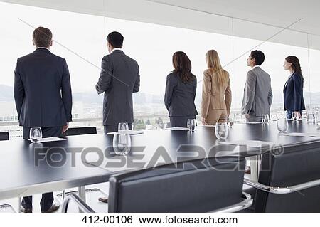 Business people in a row looking out conference room window View Large Photo Image Stock Photograph - Business people in a row looking out conference room window. Fotosearch