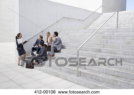 Stock Photo - Business people meeting on urban stairs. Fotosearch
