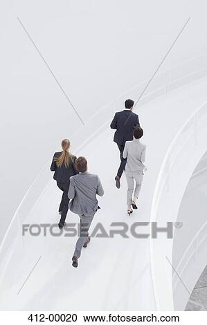 Stock Image - Business people running along elevated walkway. Fotosearch