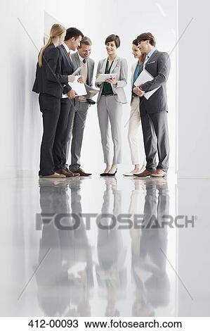 Business people with paperwork meeting in corridor View Large Photo Image Stock Image - Business people with paperwork meeting in corridor. Fotosearch