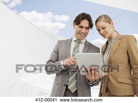 Stock Image - Businessman and businesswoman using digital tablet. Fotosearch
