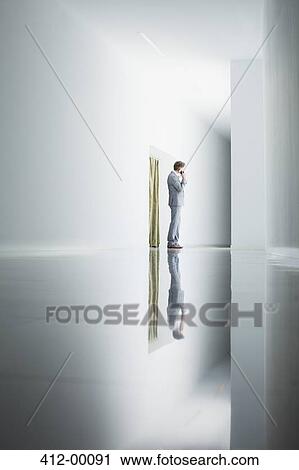 Businessman on cell phone in corridor View Large Photo Image Stock Image - Businessman on cell phone in corridor. Fotosearch