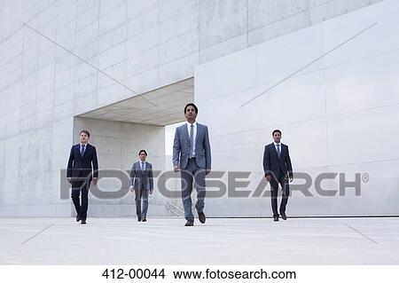 Picture - Businessmen leaving modern cultural center. Fotosearch