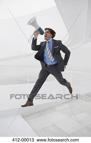 Stock Image - Leaping businessman with bullhorn. Fotosearch