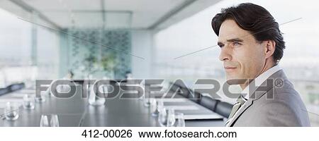 Pensive businessman with paperwork in empty conference room View Large Photo Image Stock Photograph - Pensive businessman with paperwork in empty conference room. Fotosearch