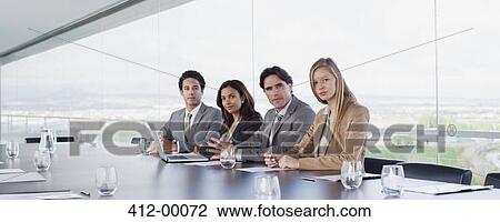 Stock Image - Portrait of confident business people at table in conference room. Fotosearch