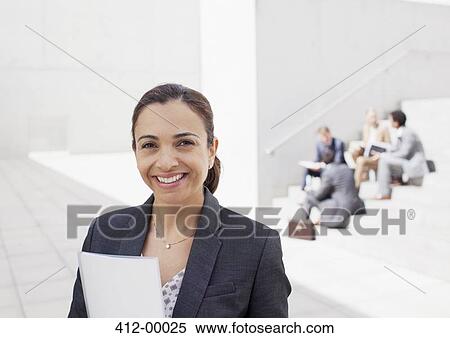 Portrait of confident businesswoman with co-workers in background View Large Photo Image Stock Photography - Portrait of confident businesswoman with co-workers in background. Fotosearch