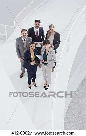 Stock Photo - Portrait of smiling business people on elevated walkway. Fotosearch