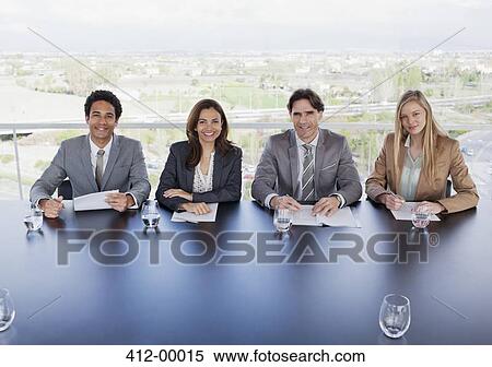 Stock Photography - Portrait of smiling business people sitting at table in conference room. Fotosearch