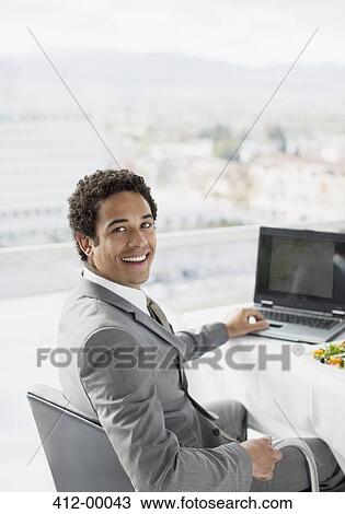 Portrait of smiling businessman using laptop in office View Large Photo Image Stock Image - Portrait of smiling businessman using laptop in office. Fotosearch