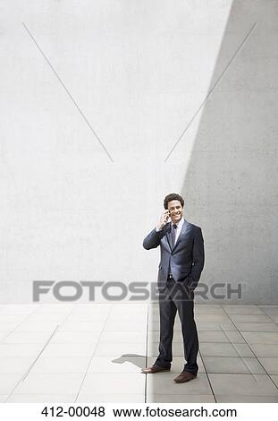 Smiling businessman talking on cell phone View Large Photo Image Stock Photo - Smiling businessman talking on cell phone. Fotosearch
