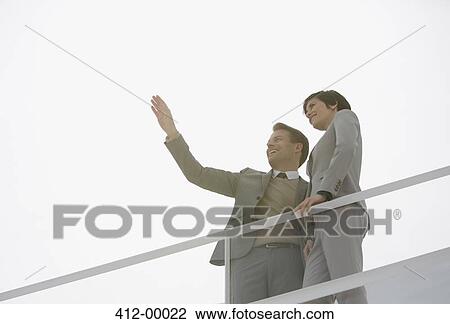 Sun shining behind gesturing businessman and businesswoman View Large Photo Image Stock Image - Sun shining behind gesturing businessman and businesswoman . Fotosearch