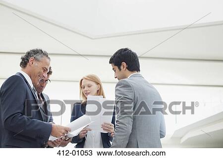 Business people discussing paperwork View Large Photo Image Stock Image - Business people discussing paperwork. Fotosearch