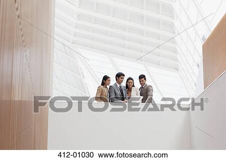 Business people reviewing paperwork in modern building View Large Photo Image Stock Image - Business people reviewing paperwork in modern building. Fotosearch
