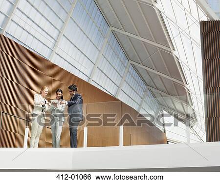 Business people using digital tablet on modern balcony in office View Large Photo Image Stock Photograph - Business people using digital tablet on modern balcony in office. Fotosearch
