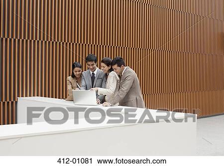 Business people using laptop at ledge in office View Large Photo Image Stock Image - Business people using laptop at ledge in office. Fotosearch