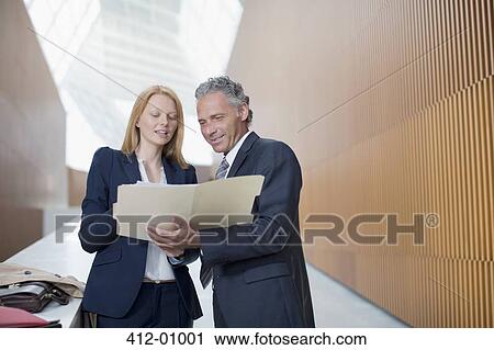 Businessman and businesswoman reviewing paperwork View Large Photo Image Stock Image - Businessman and businesswoman reviewing paperwork. Fotosearch