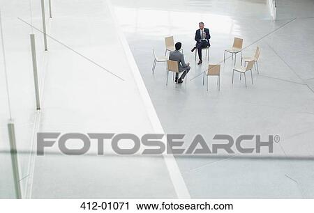 Businessmen meeting at circle of chairs in lobby View Large Photo Image Stock Image - Businessmen meeting at circle of chairs in lobby. Fotosearch
