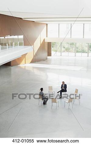 Businessmen sitting at circle of chairs in modern lobby View Large Photo Image Stock Photography - Businessmen sitting at circle of chairs in modern lobby. Fotosearch