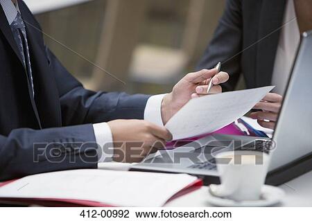 Close up of business people reviewing paperwork at cafe View Large Photo Image Stock Image - Close up of business people reviewing paperwork at cafe. Fotosearch