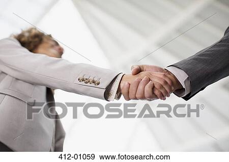 Stock Photo - Close up of businessman and businesswoman shaking hands. Fotosearch