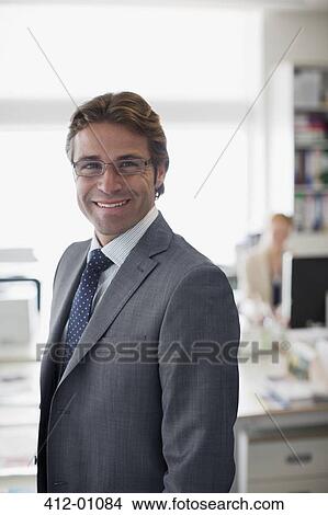 Picture - Portrait of smiling businessman in office. Fotosearch
