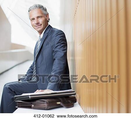 Portrait of smiling businessman with laptop and briefcase View Large Photo Image Stock Image - Portrait of smiling businessman with laptop and briefcase. Fotosearch