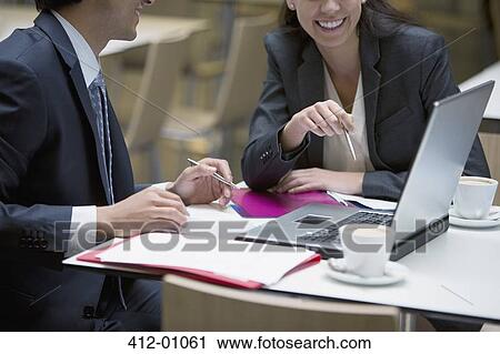 Smiling businessman and businesswoman using laptop in cafe View Large Photo Image Stock Image - Smiling businessman and businesswoman using laptop in cafe. Fotosearch