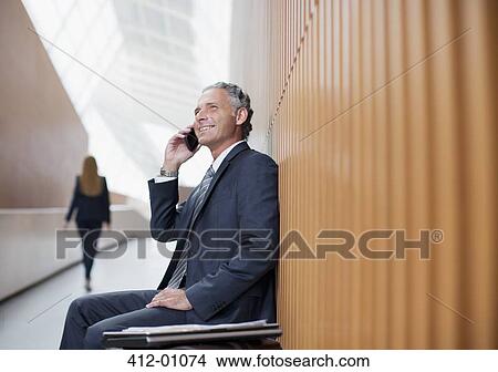 Picture - Smiling businessman talking on cell phone. Fotosearch