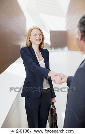 Stock Photo - Smiling businesswoman shaking hands with businessman. Fotosearch