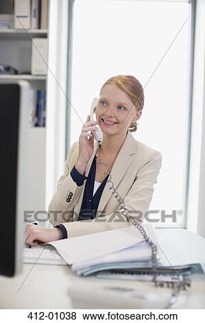 Smiling businesswoman talking on telephone View Large Photo Image Stock Photo - Smiling businesswoman talking on telephone. Fotosearch