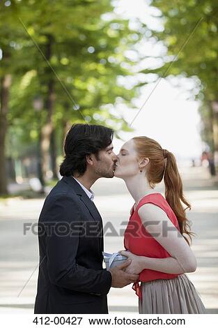 Couple kissing in park View Large Photo Image Stock Photo - Couple kissing in park. Fotosearch
