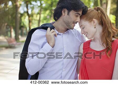 Stock Image - Happy couple hugging in park. Fotosearch