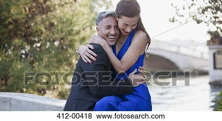 Happy well-dressed couple hugging View Large Photo Image Stock Photo - Happy well-dressed couple hugging. Fotosearch