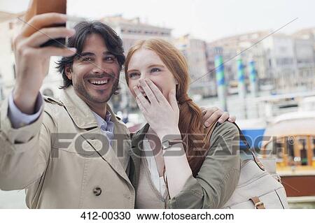 Laughing couple taking self-portrait with camera phone in Venice View Large Photo Image Stock Image - Laughing couple taking self-portrait with camera phone in Venice. Fotosearch