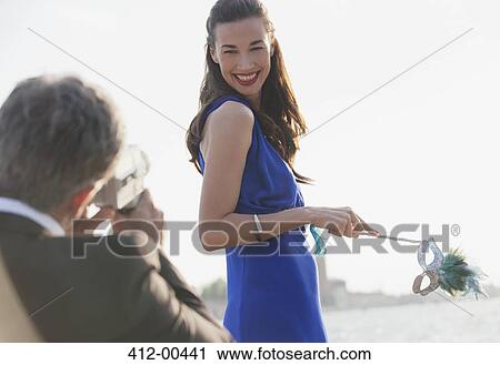 Man filming smiling woman holding mask at waterfront View Large Photo Image Stock Image - Man filming smiling woman holding mask at waterfront. Fotosearch