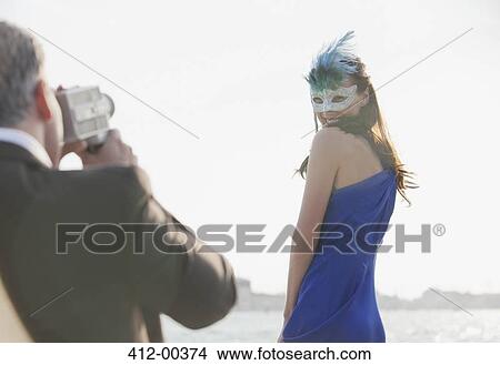 Man filming woman with mask at waterfront in Venice View Large Photo Image Picture - Man filming woman with mask at waterfront in Venice. Fotosearch