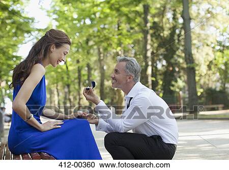 Man with engagement ring proposing to girlfriend in park View Large Photo Image Stock Image - Man with engagement ring proposing to girlfriend in park. Fotosearch