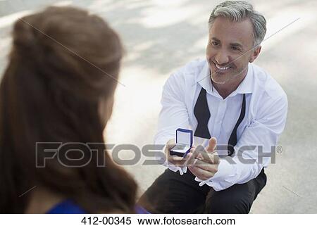 Man with engagement ring proposing to woman View Large Photo Image Stock Photography - Man with engagement ring proposing to woman. Fotosearch
