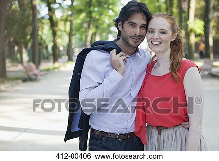 Portrait of smiling couple in park View Large Photo Image Stock Photograph - Portrait of smiling couple in park. Fotosearch