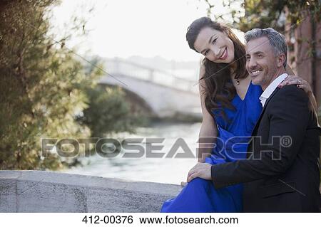 Portrait of smiling well-dressed couple at waterfront View Large Photo Image Stock Photograph - Portrait of smiling well-dressed couple at waterfront. Fotosearch