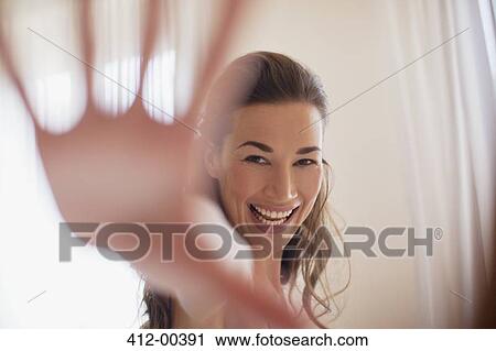 Stock Image - Portrait of smiling woman with hand outstretched. Fotosearch