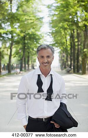 Portrait of well-dressed man in park View Large Photo Image Stock Photo - Portrait of well-dressed man in park. Fotosearch