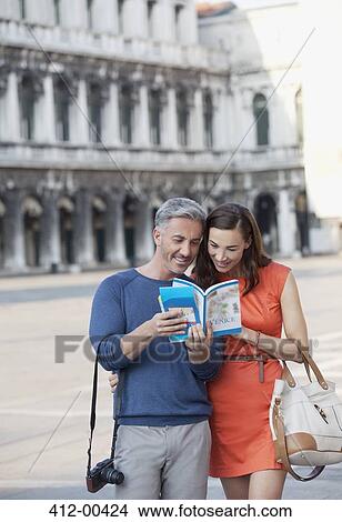 Smiling couple looking at guidebook in St. Mark's Square in Venic View Large Photo Image Picture - Smiling couple looking at guidebook in St. Mark's Square in Venic. Fotosearch
