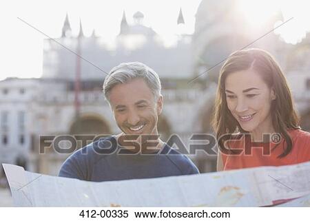 Stock Photography - Smiling couple looking at map in Venice. Fotosearch